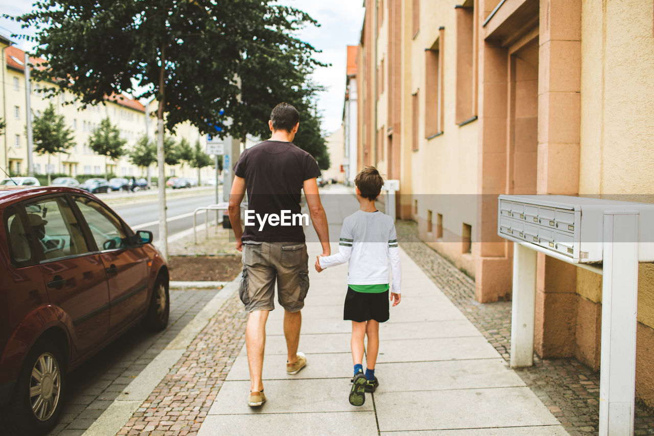 FULL LENGTH REAR VIEW OF PEOPLE WALKING ON STREET