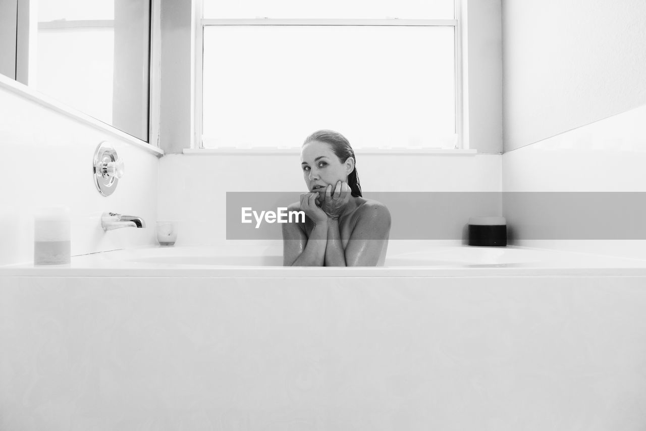 Woman sitting in bathtub