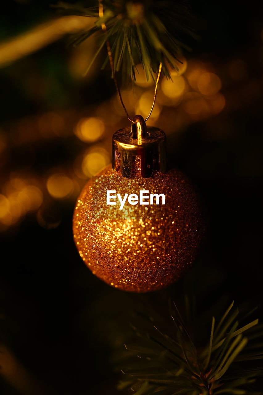 light, holiday, yellow, macro photography, celebration, christmas, christmas decoration, branch, tree, decoration, illuminated, christmas tree, no people, christmas ornament, night, close-up, darkness, plant, flower, tradition, christmas lights, nature, focus on foreground, gold, lighting, hanging, lighting equipment, event, sphere, outdoors, shiny
