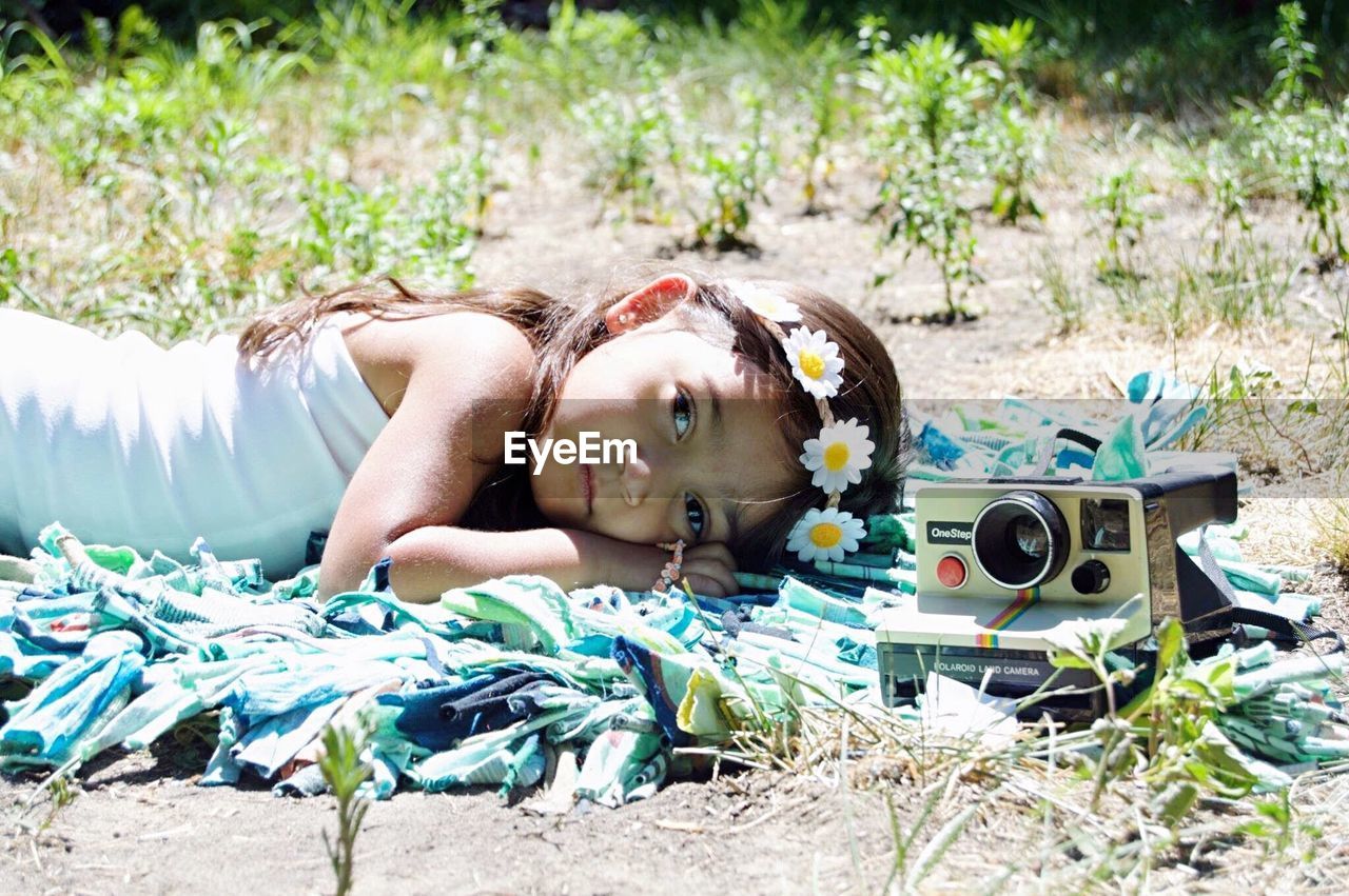 PORTRAIT OF YOUNG WOMAN LYING DOWN ON GROUND