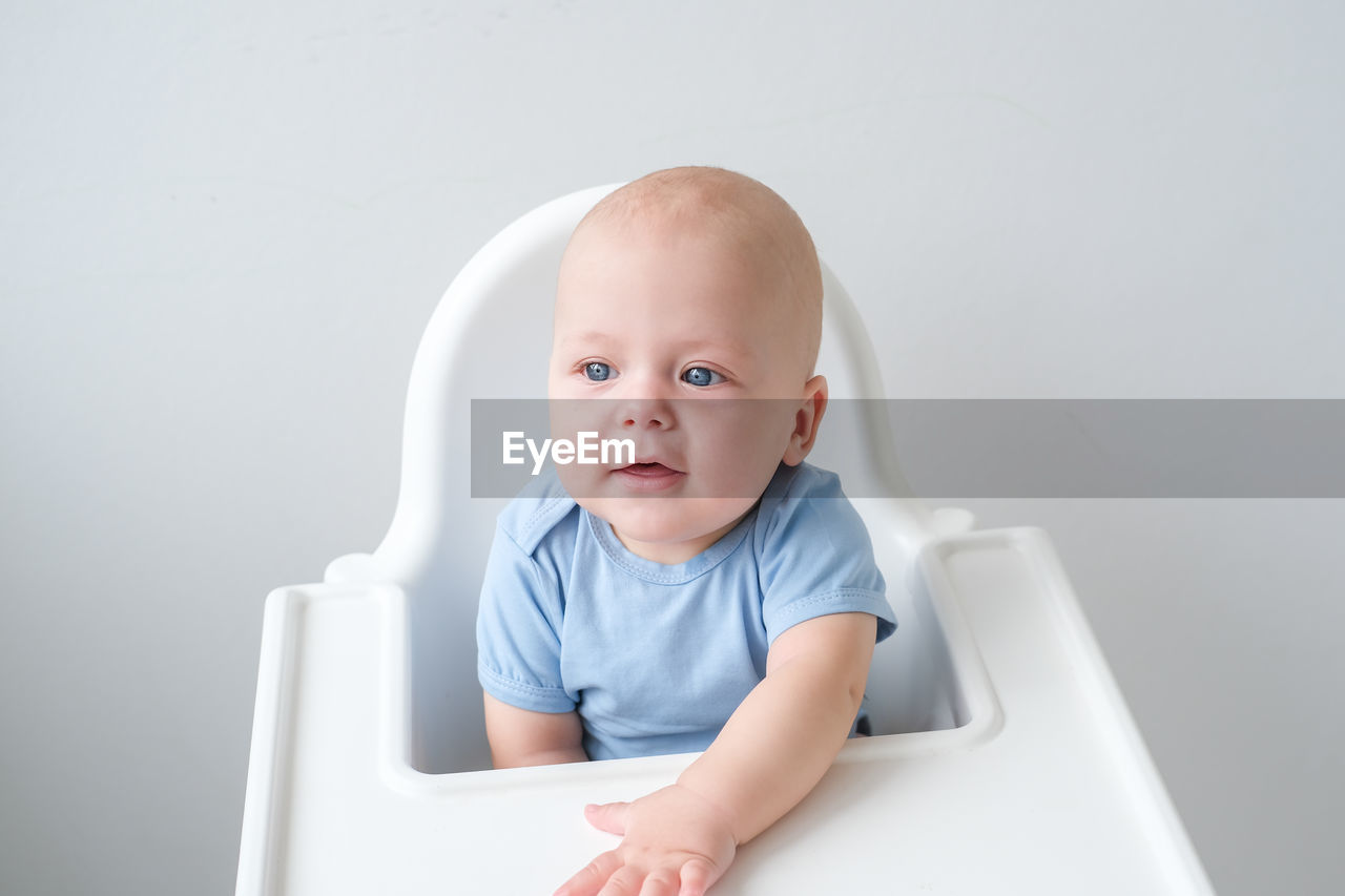 portrait of cute baby boy sitting on table