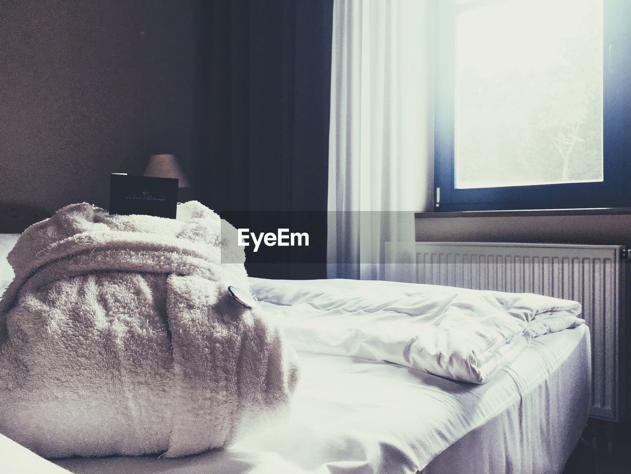 Bathrobe on bed against window