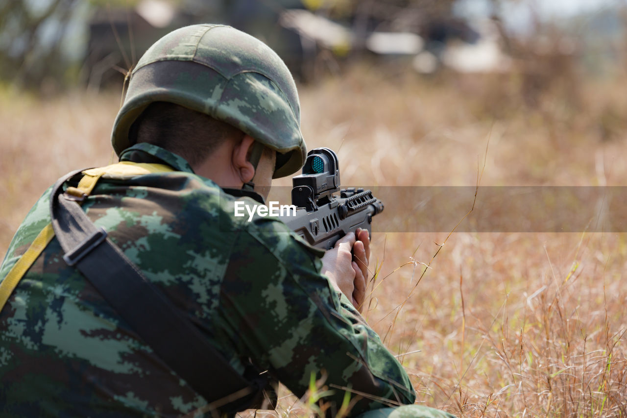 Close-up of army soldier shooting with rifle