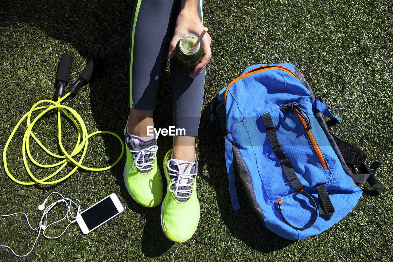 Low section of man wearing shoes on grass