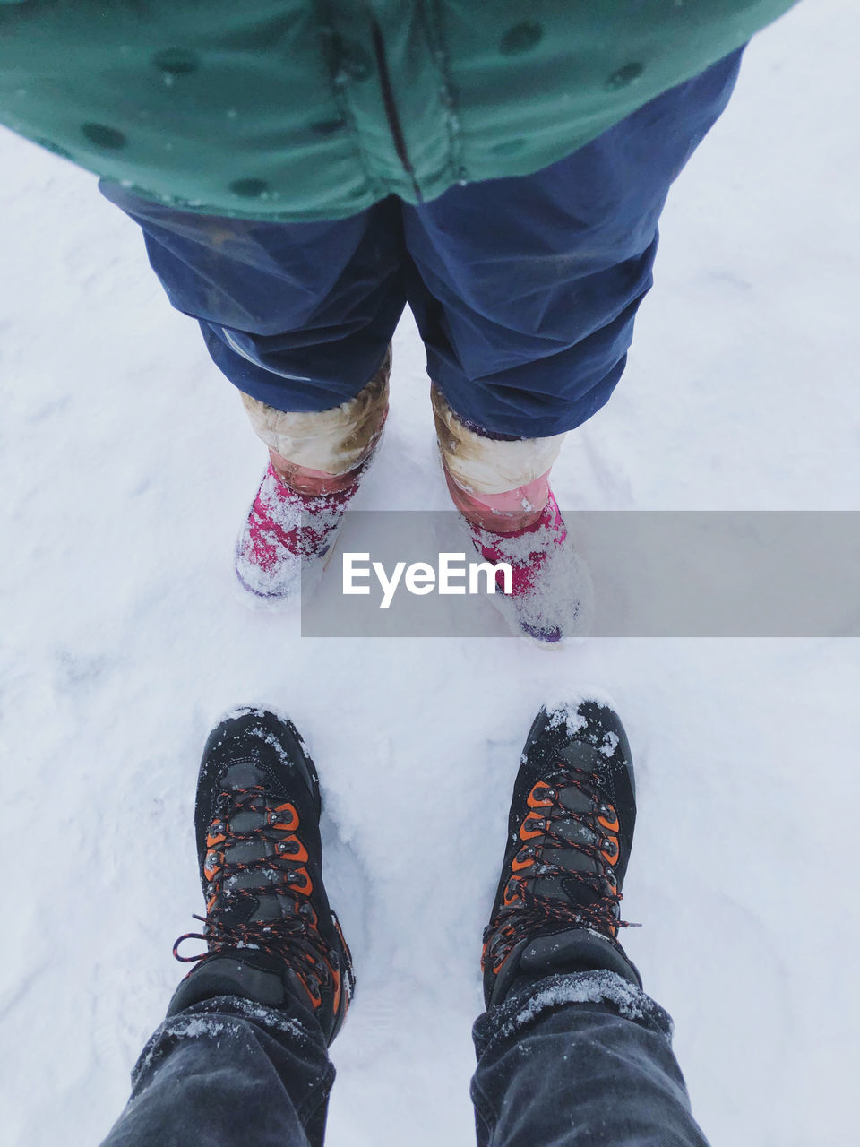 High angle view of father and child winter shoes on snow