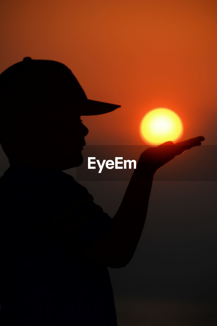 rear view of silhouette man standing against sky during sunset