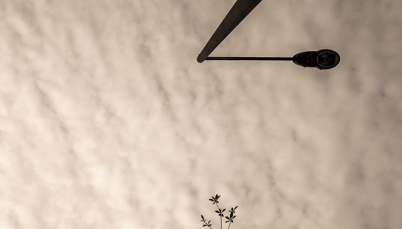 Low angle view of street light against cloudy sky at dusk