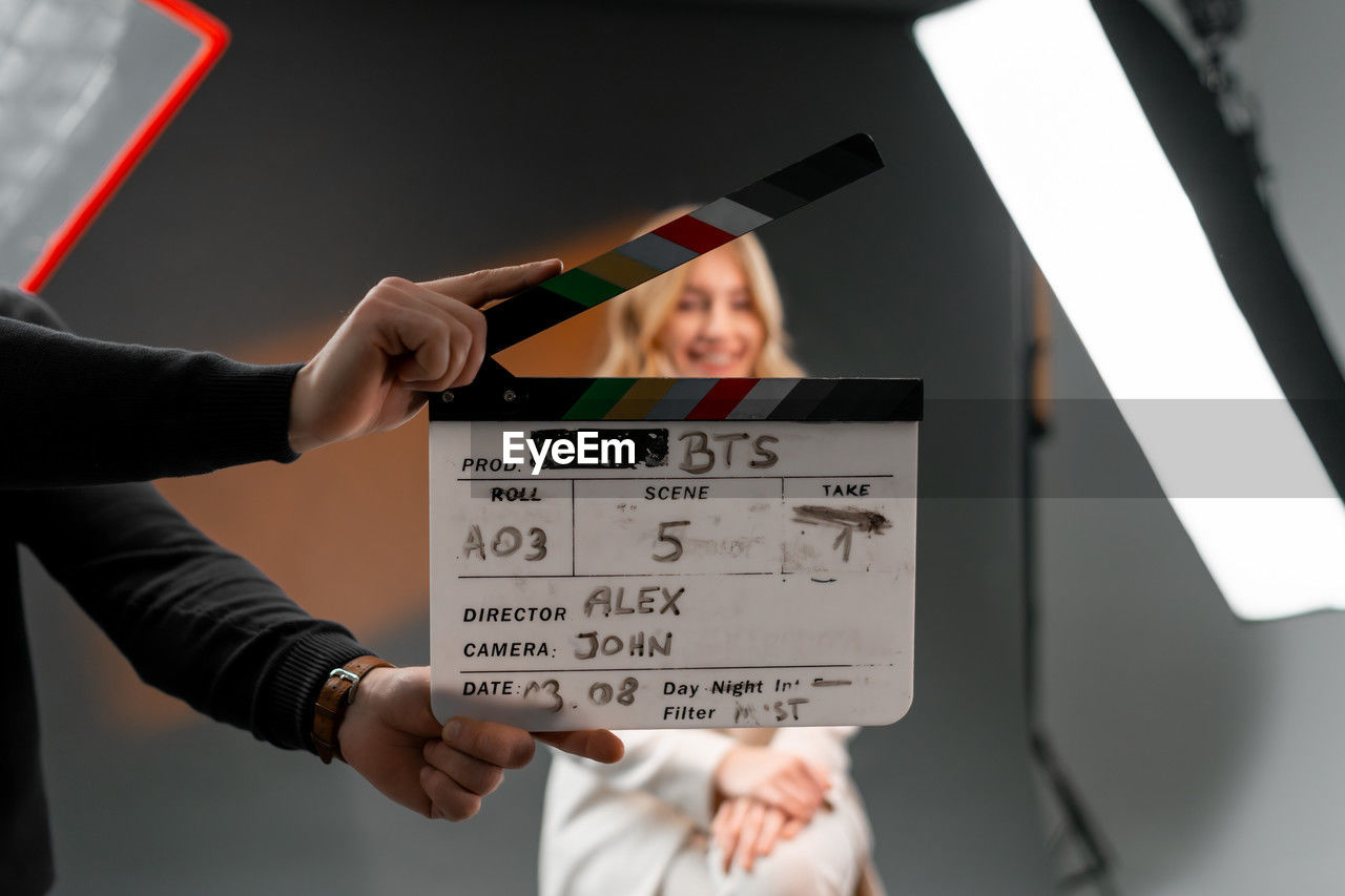 Woman gestures with clapper board in front of man, creating fun event display