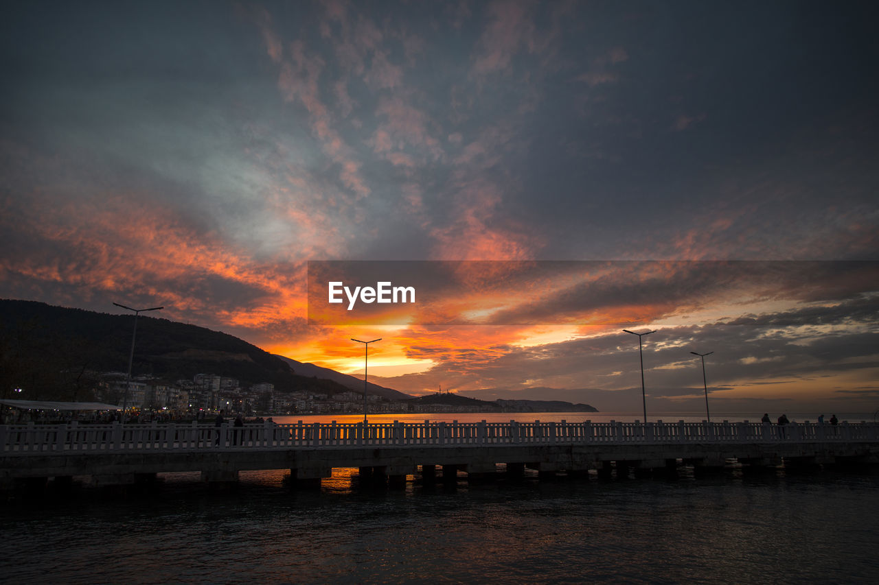 Bridge over river against sky during sunset