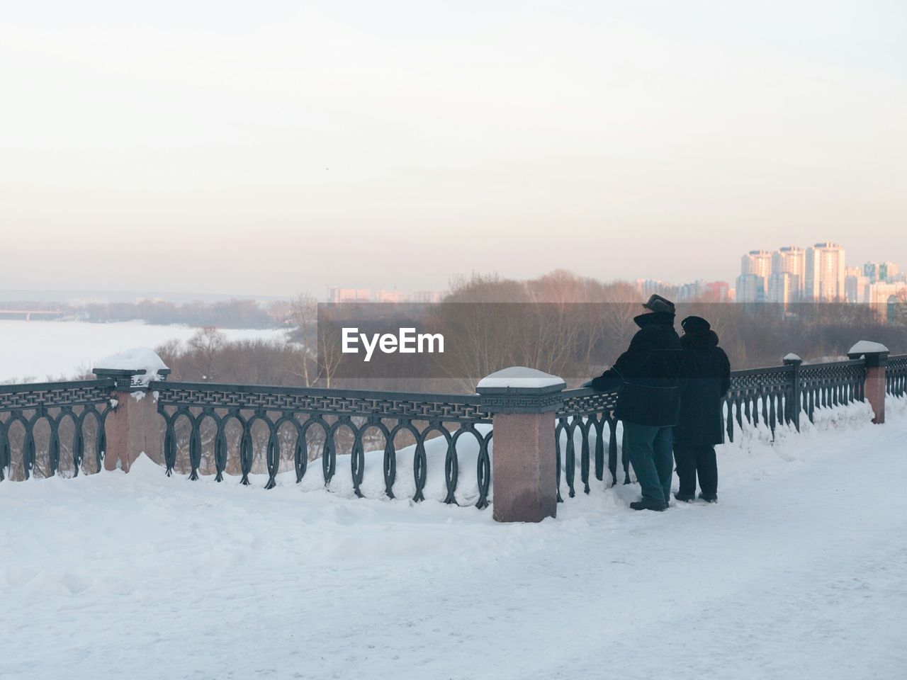 A couple of people at the embankment in winter