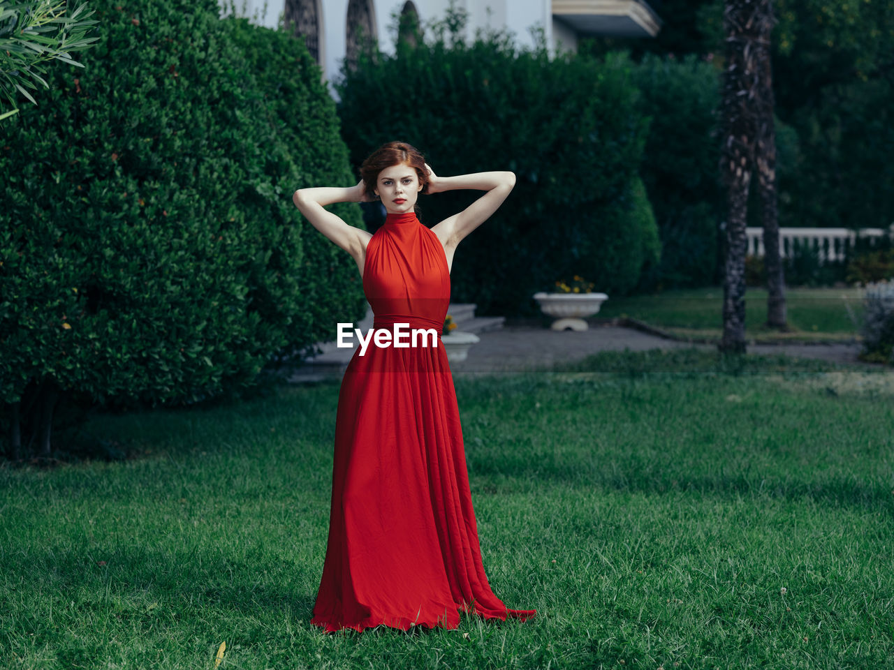 FULL LENGTH PORTRAIT OF A WOMAN STANDING ON GRASS