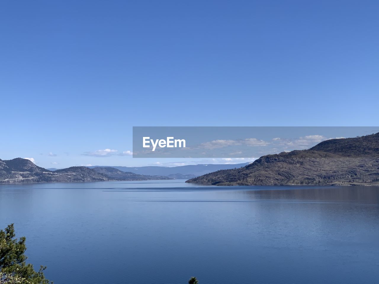 Scenic view of lake against clear blue sky