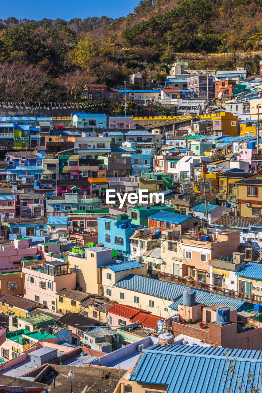 architecture, town, building exterior, city, building, built structure, residential district, cityscape, house, aerial photography, high angle view, residential area, roof, neighbourhood, crowded, nature, community, crowd, land, environment, travel destinations, outdoors, travel, day, water, suburb, landscape, mountain, urban area, multi colored, bird's-eye view, tourism, sky, city life, street, sea