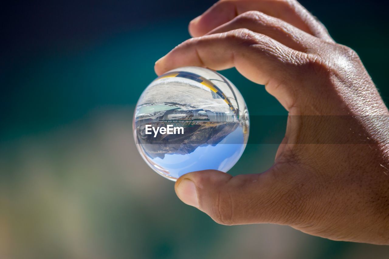 Midsection of person holding crystal ball