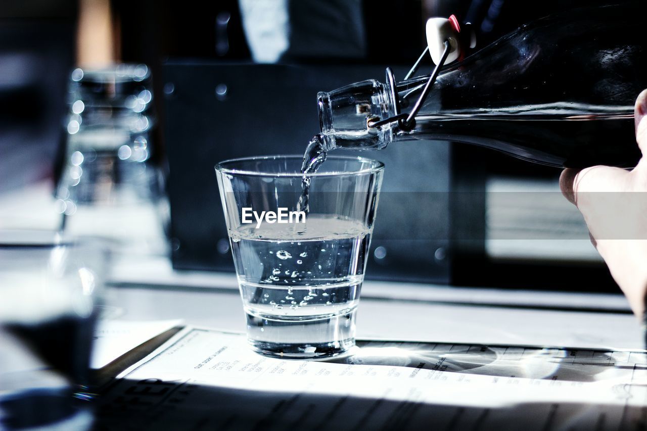 Close-up of drink being poured in glass on table