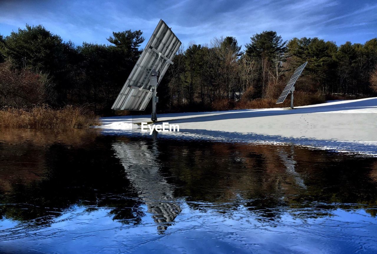 Reflection of solar panel on lake during winter
