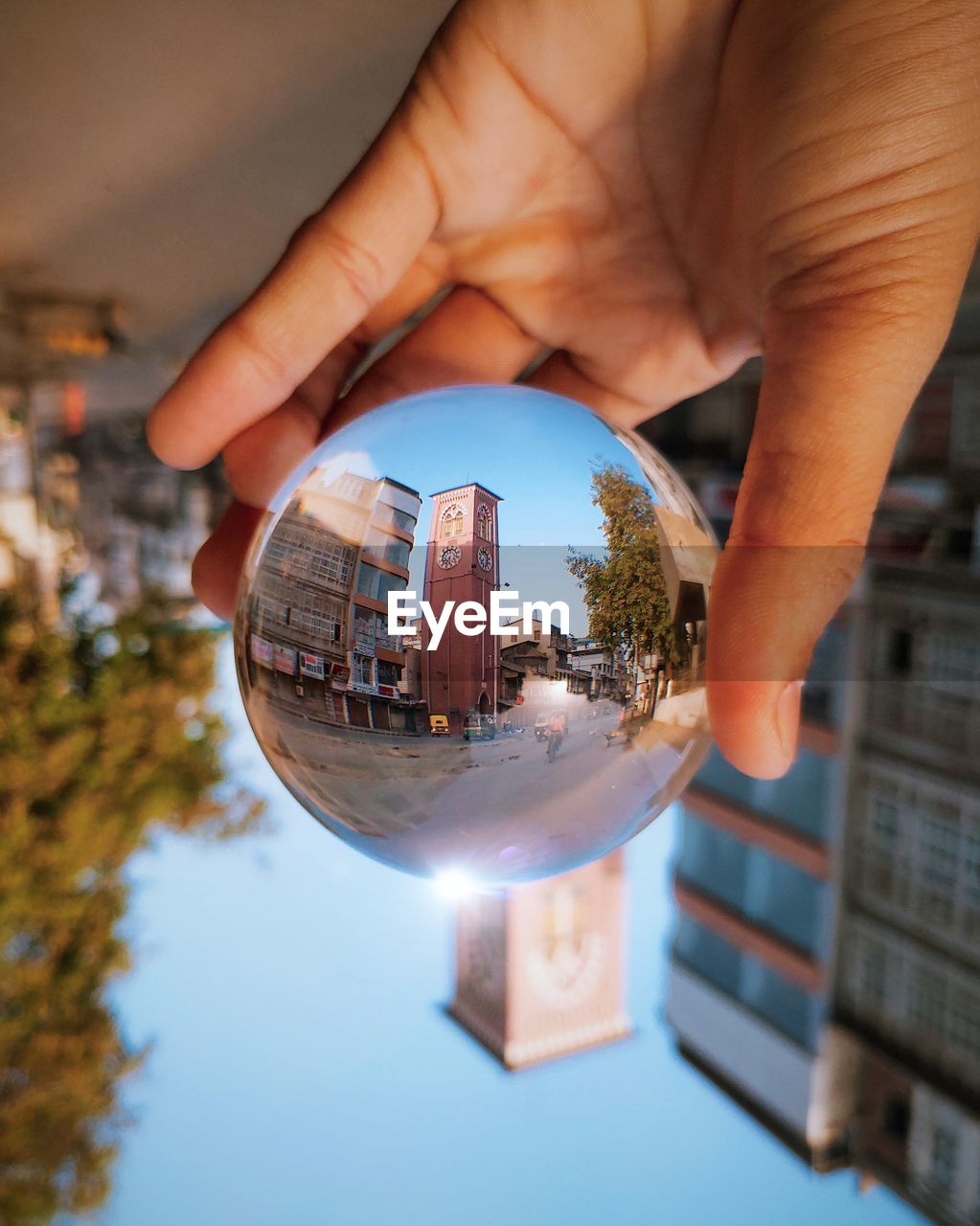 Close-up of person holding glass of building