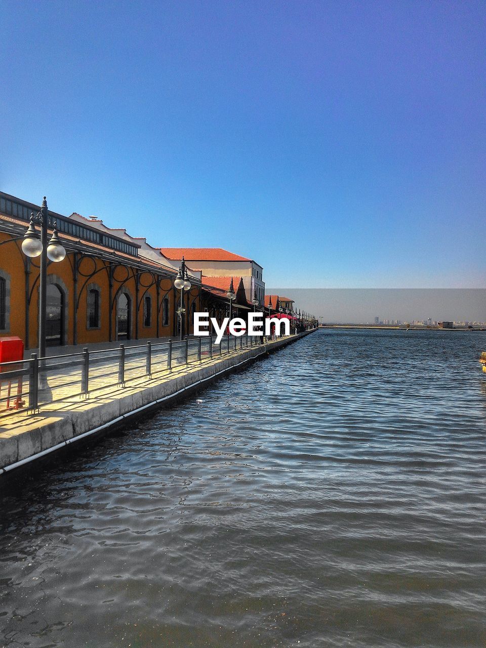 Train at railroad station against clear blue sky