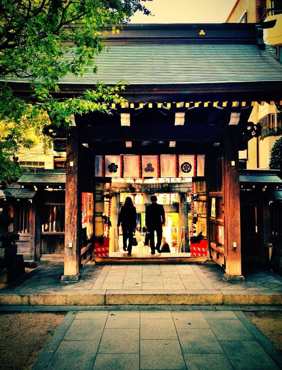 Rear view of man and woman entering store