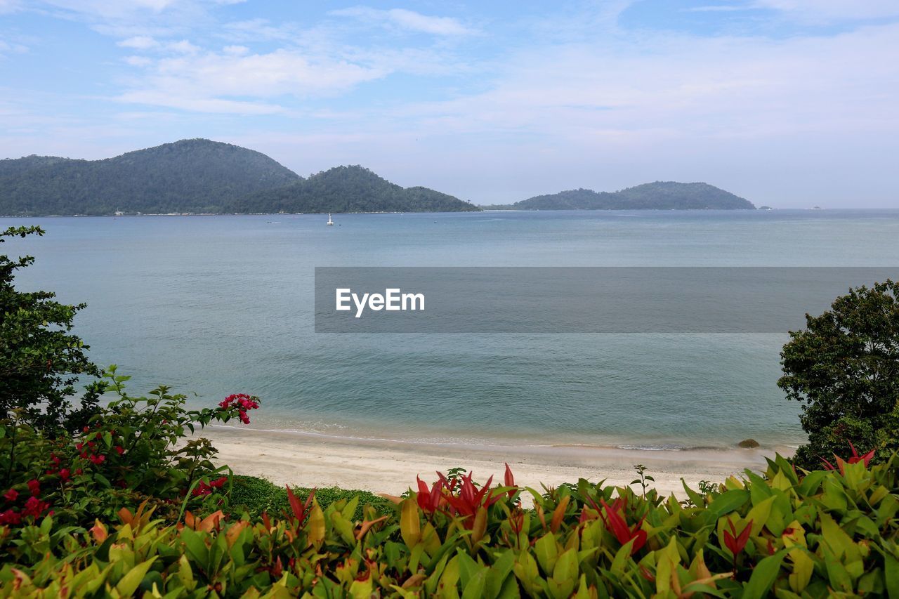 SCENIC VIEW OF SEA BY MOUNTAIN AGAINST SKY