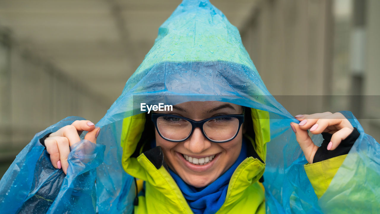 Portrait of smiling woman wearing raincoat outdoors