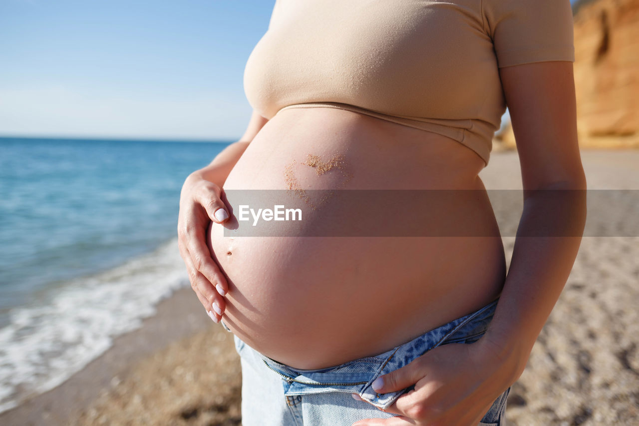 MIDSECTION OF WOMAN WEARING HAT