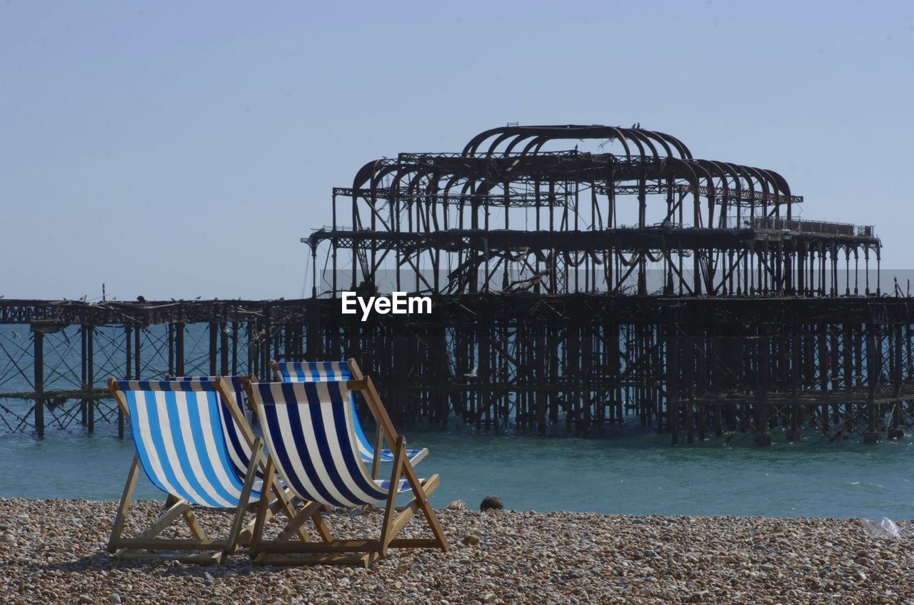 Chairs against brighton pier at beach