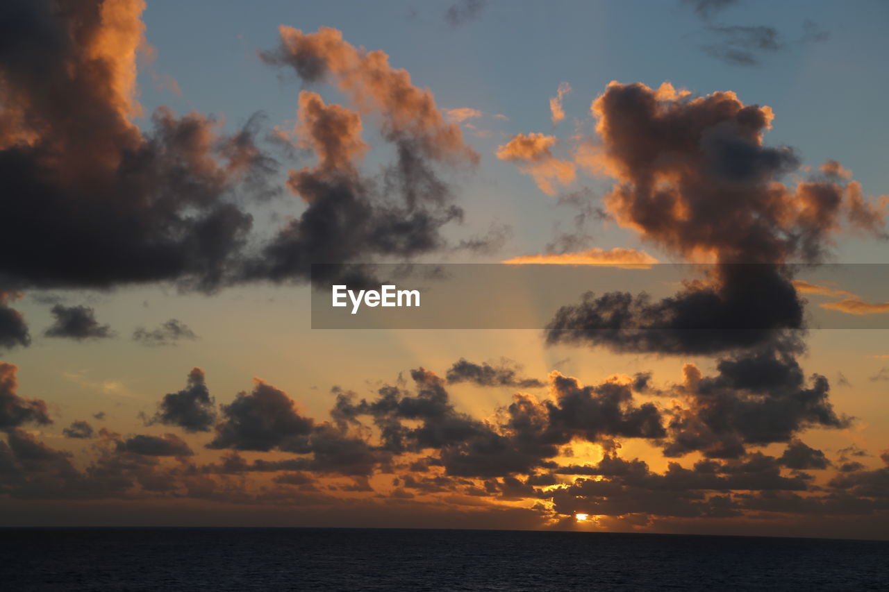 Scenic view of dramatic sky over sea during sunset