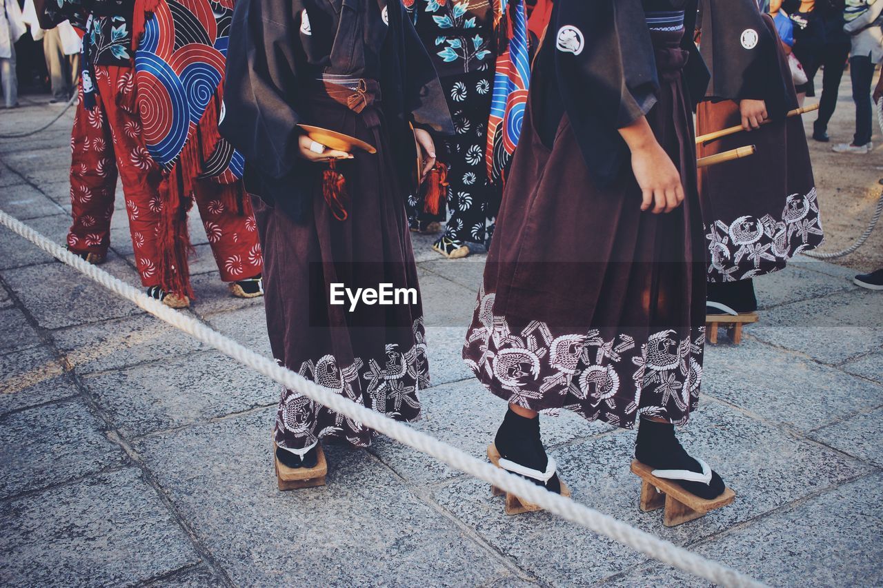 Low section of women in traditional clothing walking on street