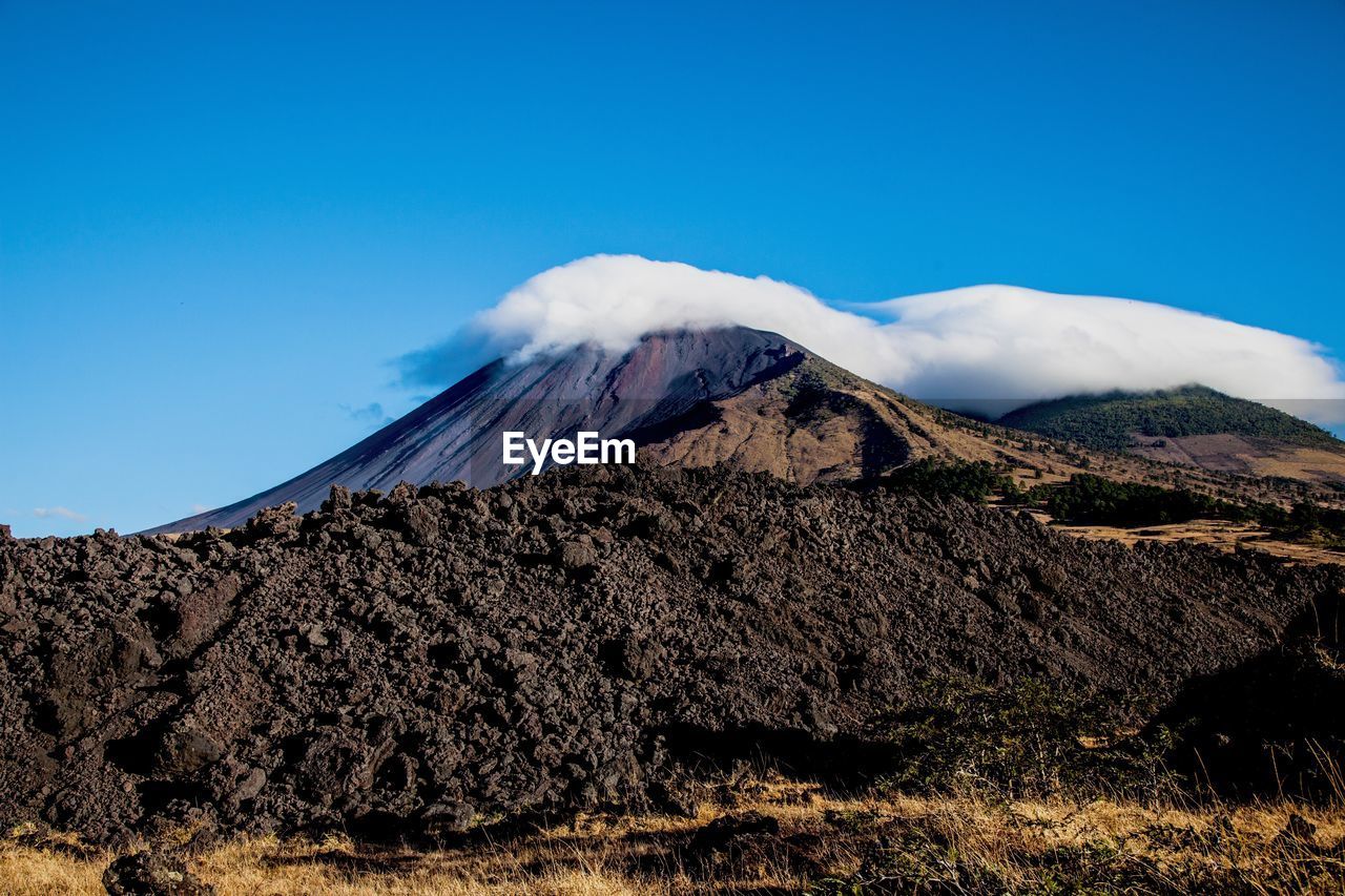 Cloud on mountain against blue sky