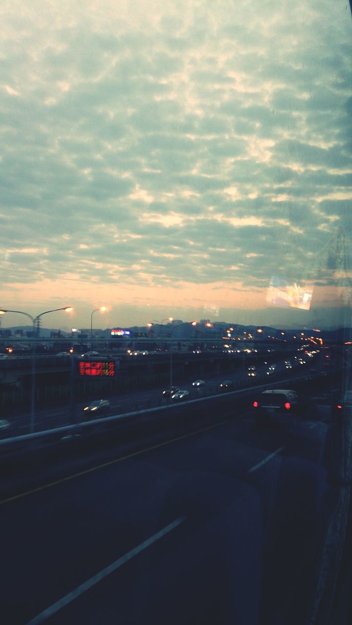 Traffic on road at sunset seen through car window