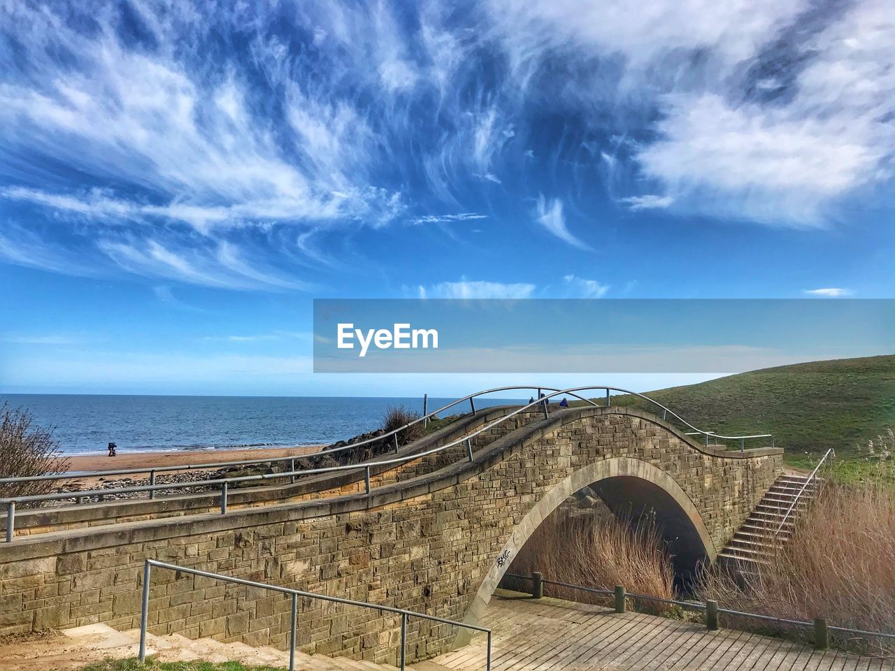 Arch bridge over sea against sky