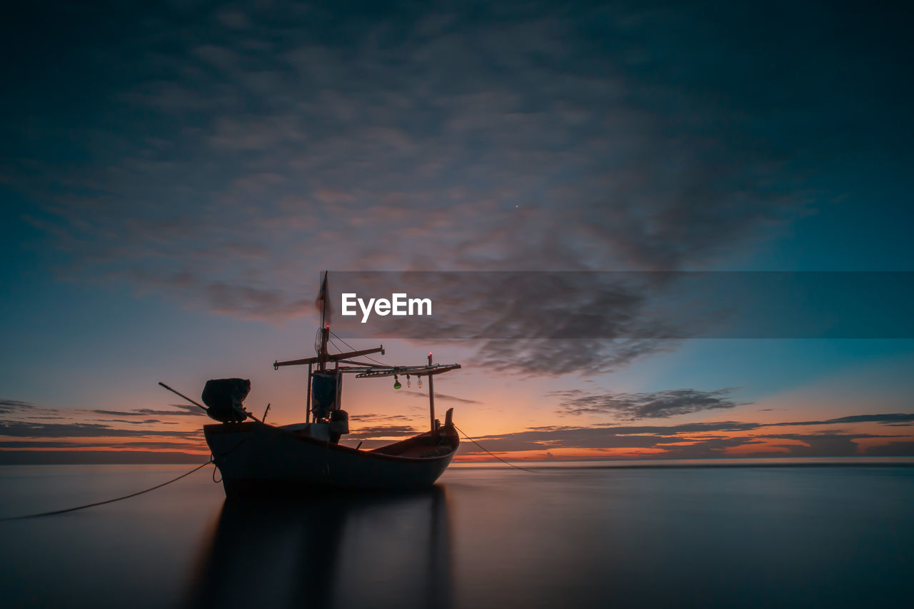 Silhouette of sailboat in sea against sky during sunset