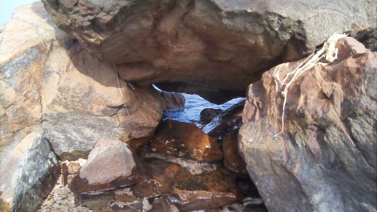 CLOSE-UP OF ROCK FORMATIONS IN WATER