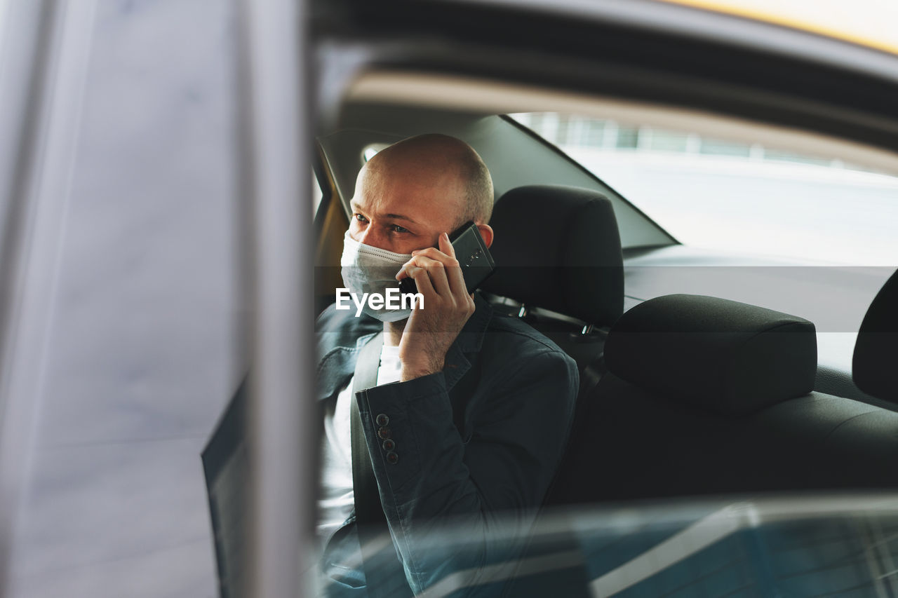 Businessman talking on phone while sitting in car