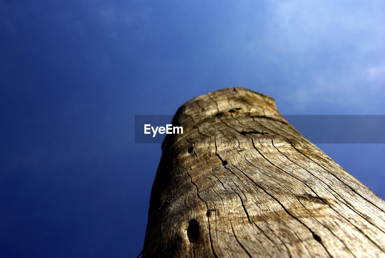 Low angle view of wood against blue sky