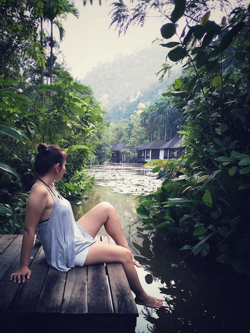 Young woman sitting on plant looking at view