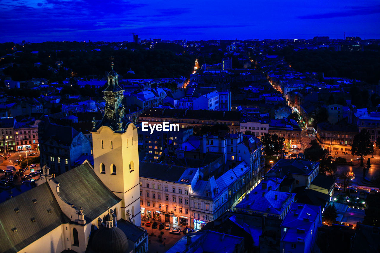 HIGH ANGLE VIEW OF ILLUMINATED CITYSCAPE AGAINST SKY