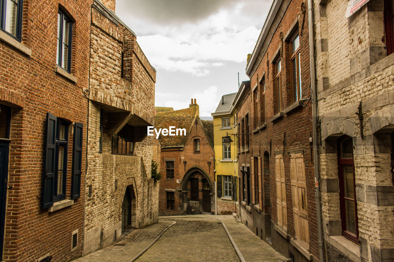 Street amidst houses against sky