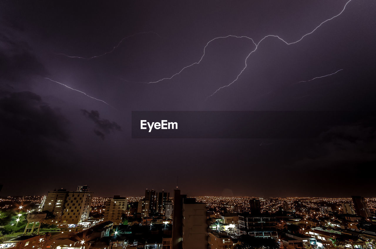 Aerial view of illuminated city against sky at night