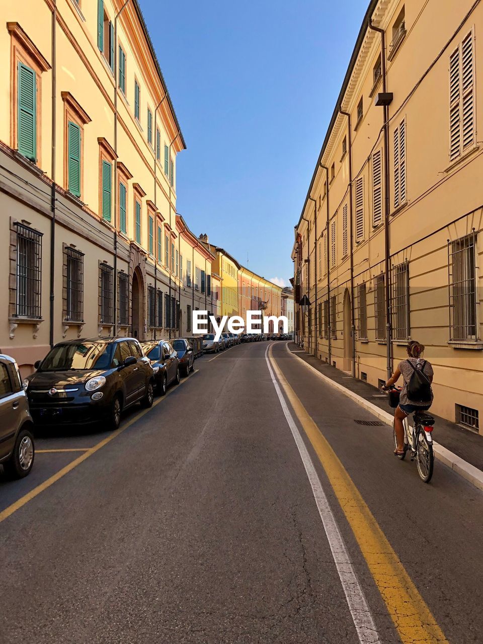 VEHICLES ON ROAD AMIDST BUILDINGS IN CITY