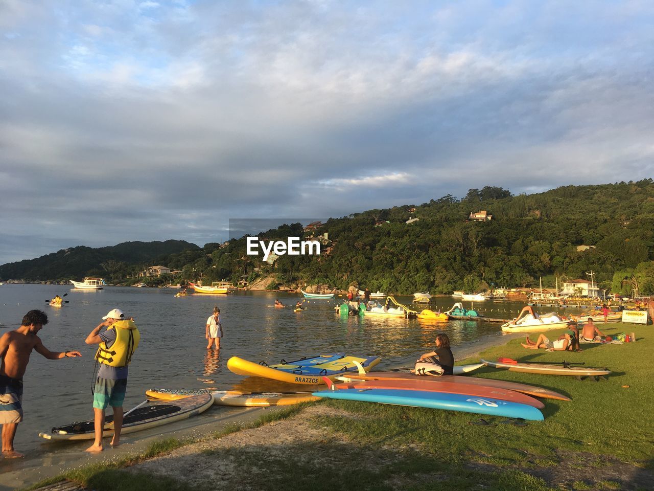 PEOPLE ON LAKE AGAINST SKY