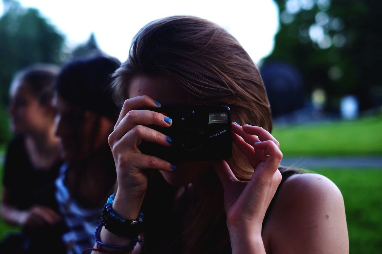 Close-up of woman photographing at park
