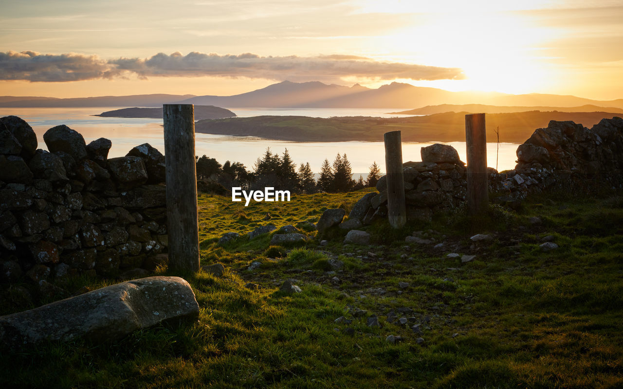 Old ruins with sea in background against sky during sunset