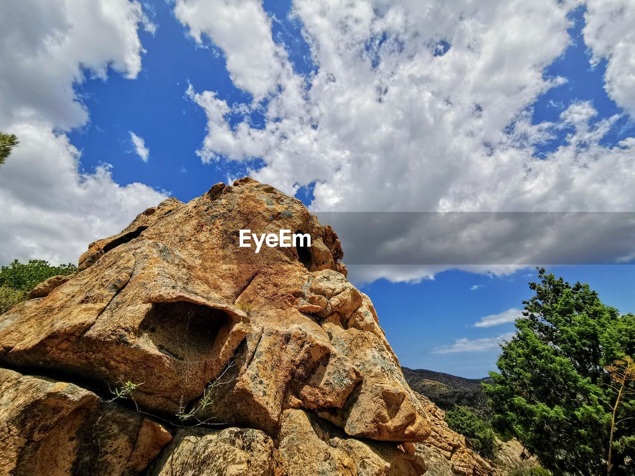 LOW ANGLE VIEW OF ROCK FORMATION AND TREE AGAINST SKY