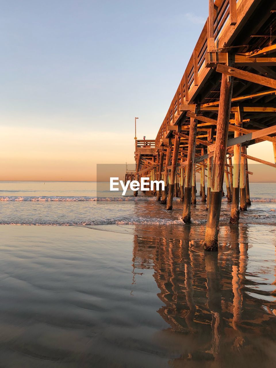 Pier on sea against sky at sunset