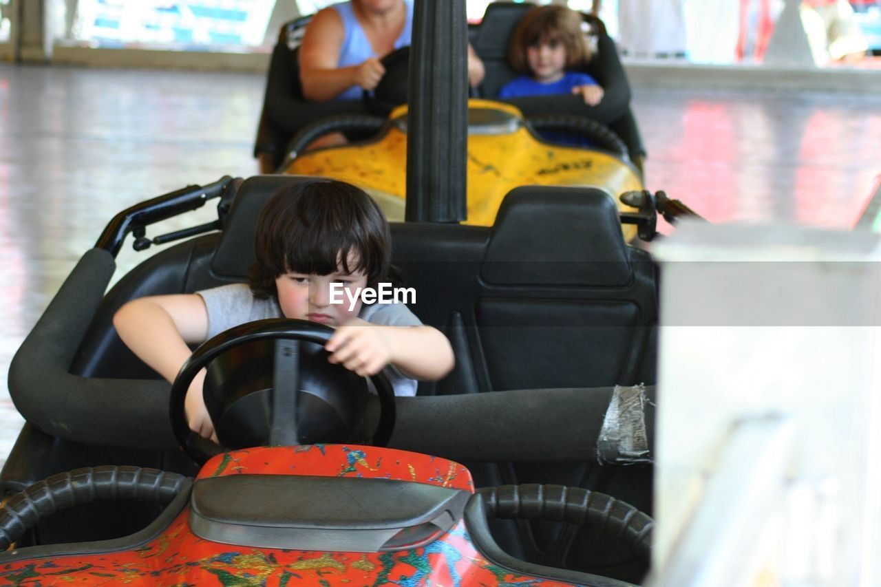 Sad boy sitting in bumper car