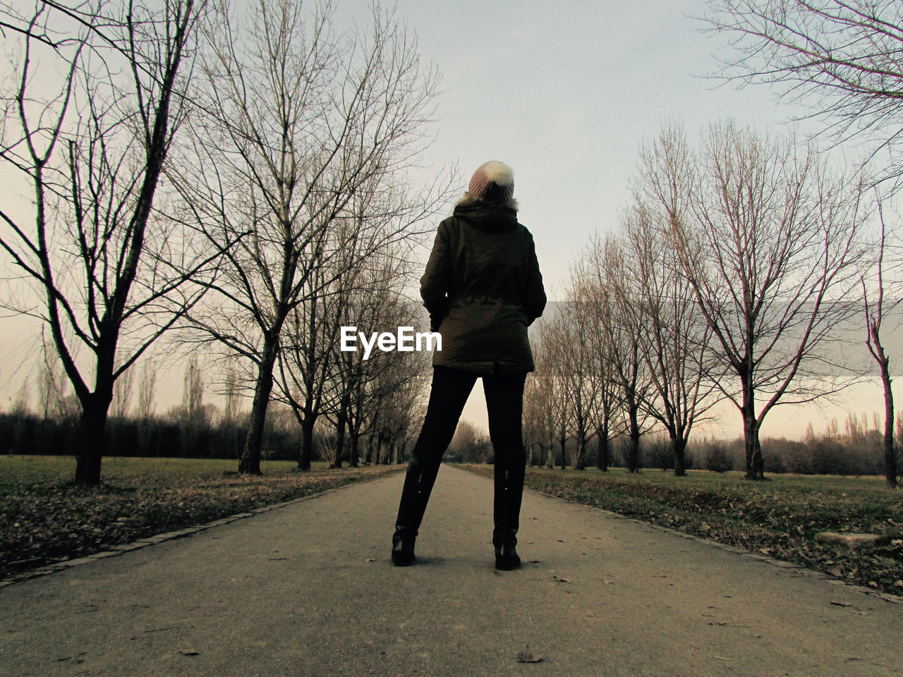 FULL LENGTH REAR VIEW OF MAN WALKING ON BARE TREES