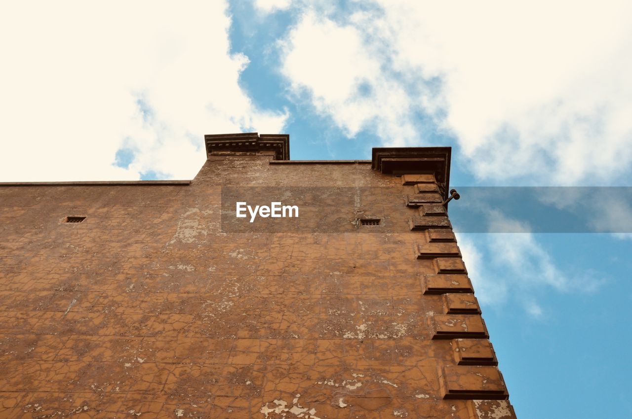 LOW ANGLE VIEW OF BUILDING ROOF AGAINST CLOUDY SKY