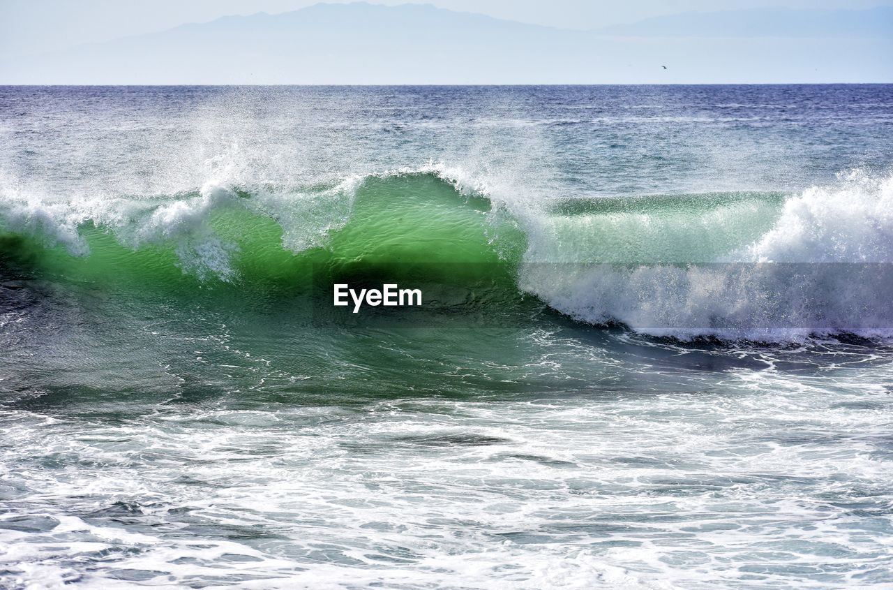 Scenic view of waves in sea against sky